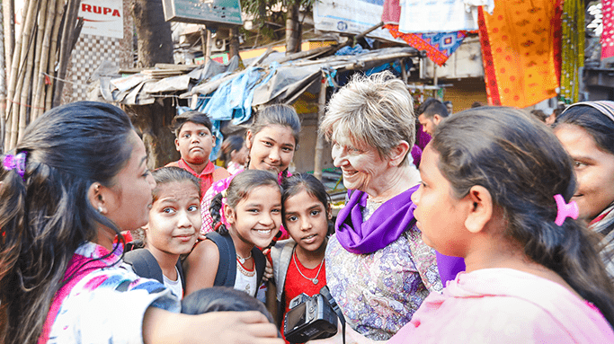 Woman meets with a group of children in a slum.