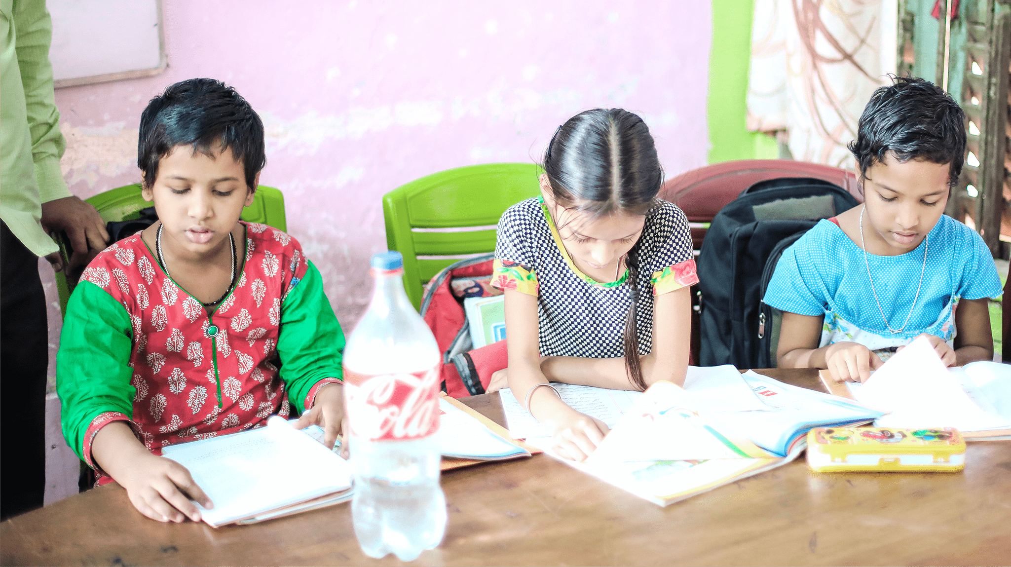 A group of children sitting at a table with books.