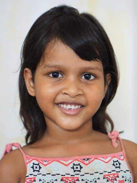 A young girl is smiling for the camera.